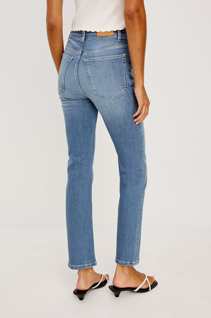 Bixby Mid-Rise Slim Straight Jean in High Stretch Denim With 25" Inseam, Zip Fly, and 5-Pockets in Vista Blue Colorway - Lower Body Back View Featured on Model