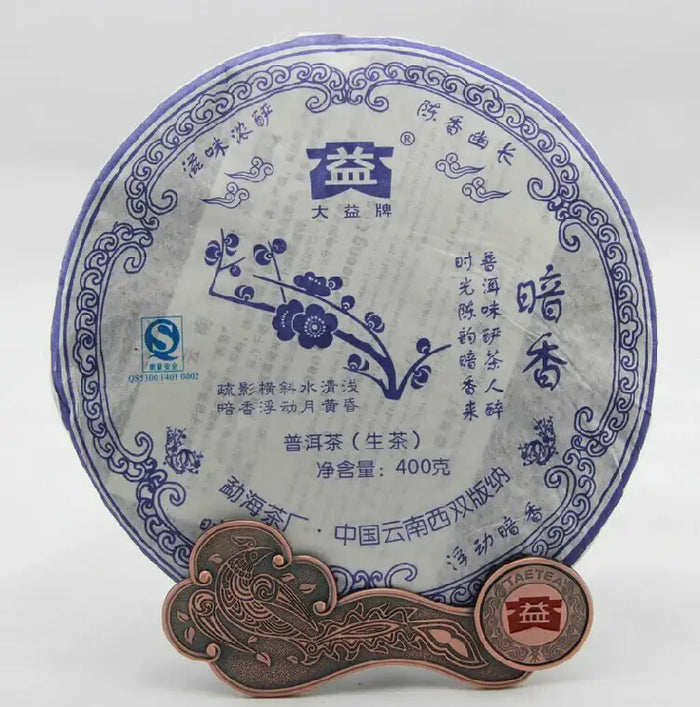 Yunnan raw puerh tea cake with blue floral Chinese design, 400g, displayed upright with tea coin