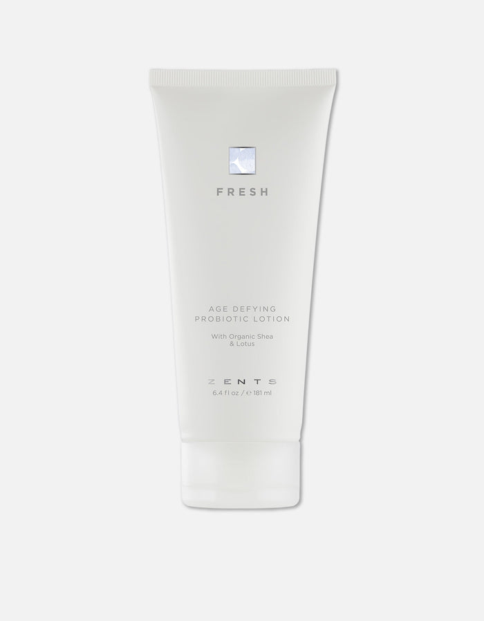 White tube of Age Defying Probiotic Lotion | Zents with minimalist design, featuring organic shea and lotus for skincare and wellness.
