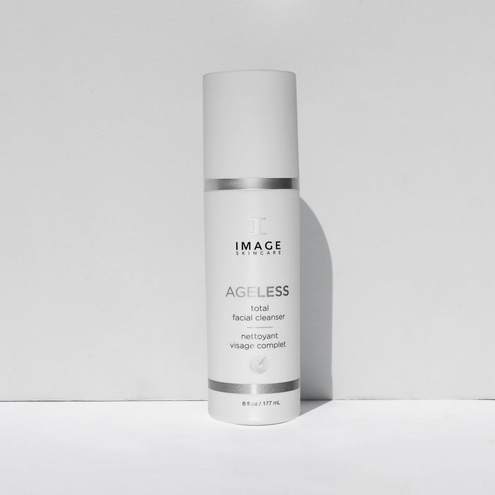 Bottle of AGELESS total facial cleanser | IMAGE Skincare, a white skincare product container with silver accents designed for a complete facial cleansing routine.
