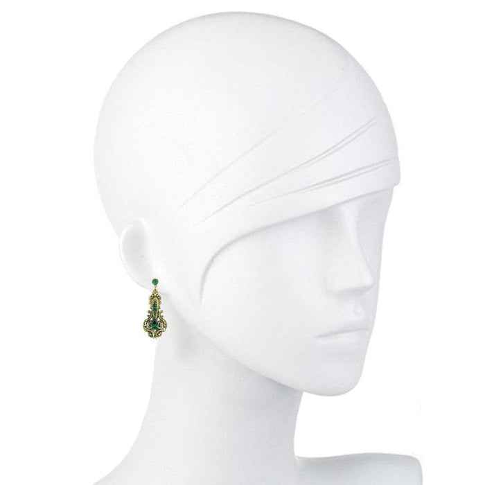 Green and gold drop earrings on a mannequin.