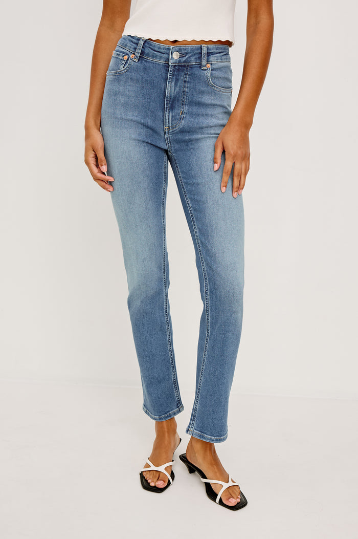 Bixby Mid-Rise Slim Straight Jean in High Stretch Denim With 25" Inseam, Zip Fly, and 5-Pockets in Vista Blue Colorway - Lower Body Front View Featured on Model
