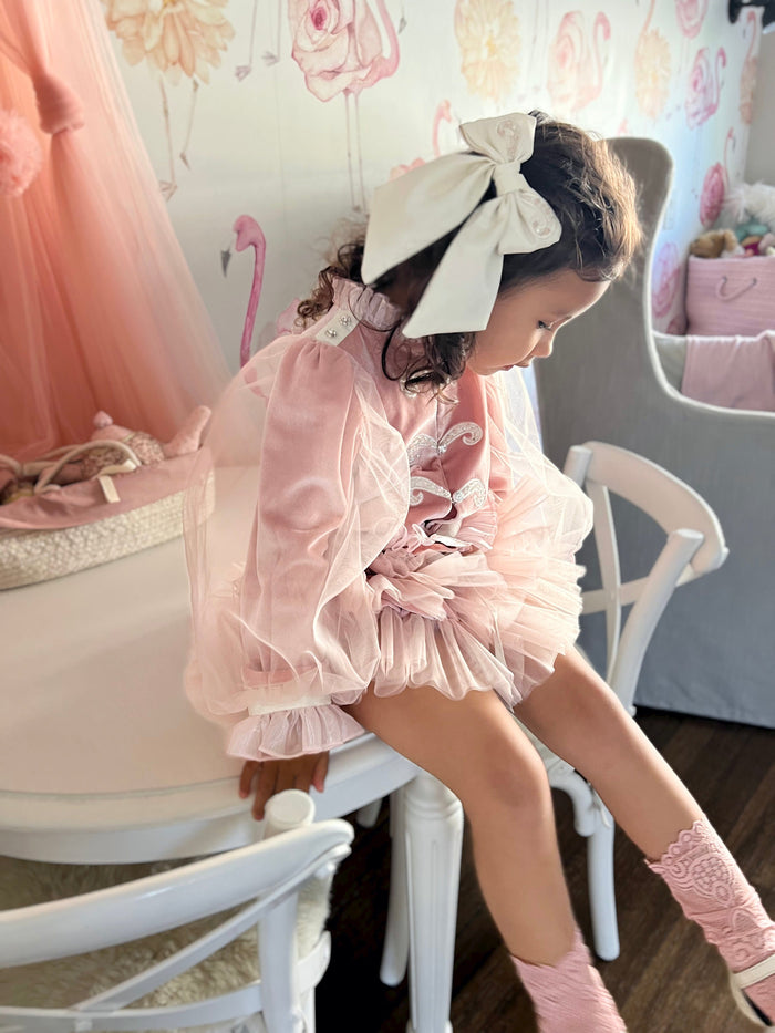 Toddler seated wearing Clara Pink Velour Jacket and Bloomers Set, showing layered pink tulle bloomers and delicate ivory trim details.