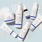 Various IMAGE Skincare CLEAR CELL salicylic gel cleanser | IMAGE Skincare products including tubes, jars, and pump bottles displayed on a light blue background with cleanser textures nearby.