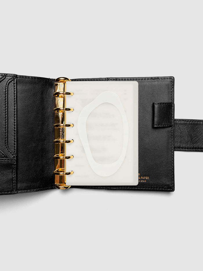 Continuation Planner Cover + Dashboard Set in Pocket. Milky white frosted plastic cover with a spot gloss organic shape over a black-printed paper dashboard. Image 3 of 3.