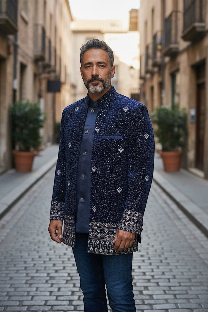 Kurti Connection USA navy blue Bandhgala jacket with silver embroidery and patterned cuffs. Model wears it with a blue shirt and jeans.