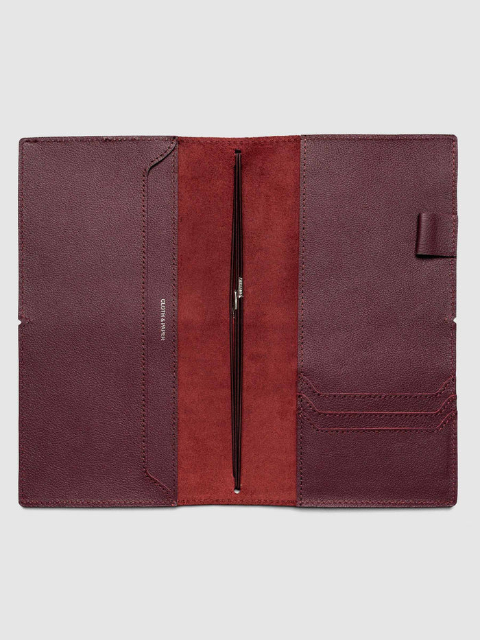 Deep red leather travel notebook cover in size A5 Slim shown open with interior pockes and elastic bands.