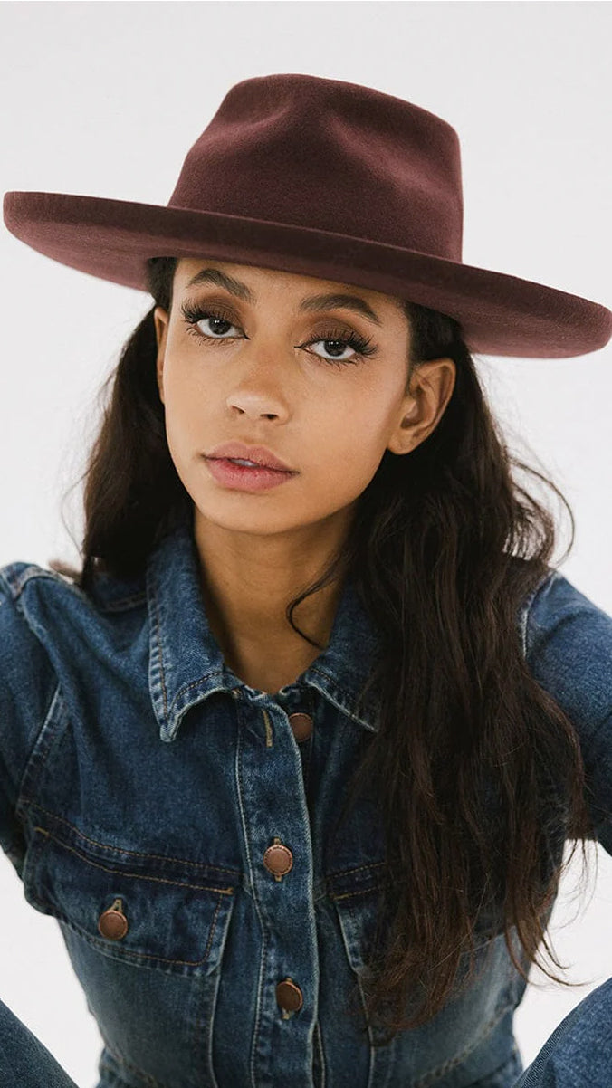 Woman wearing dark cherry wide-brim fedora hat and denim jacket, stylish women's accessory from The House of Blondie