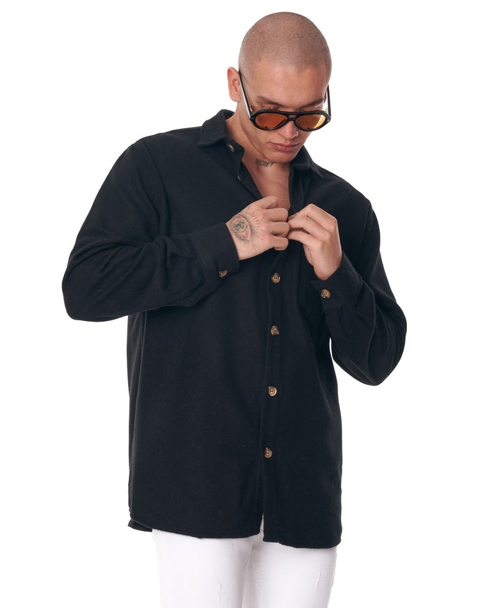 Martin Valen men's black lumberjack shirt, front mid-body view with model buttoning the placket