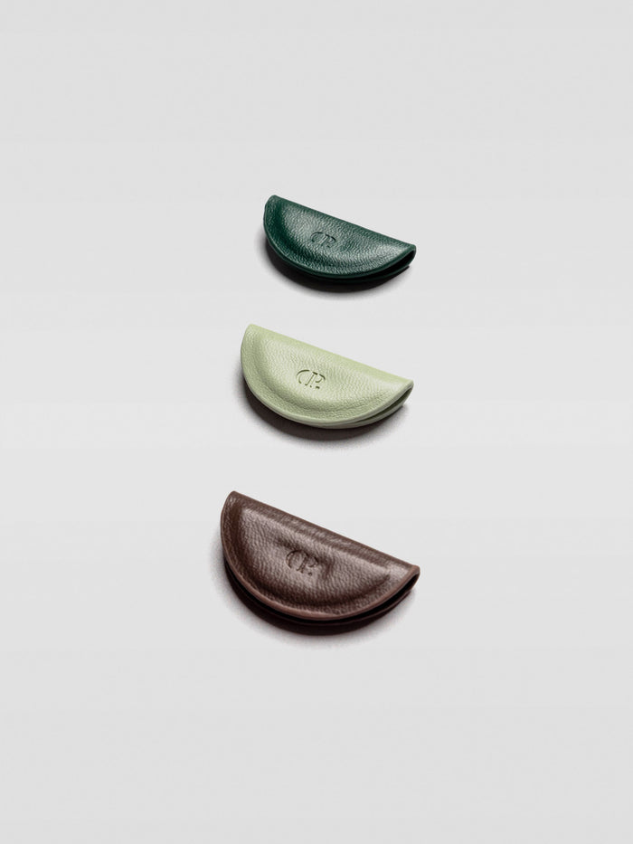Angled view of the three half-moon bookmarks stacked in a staggered formation to show their thickness and texture, emphasizing the CP debossed logo.