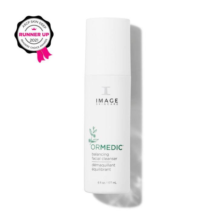 White cylindrical bottle of ORMEDIC® balancing facial cleanser | IMAGE Skincare with minimalist green leaf design and award badge for skincare runner up 2021.