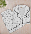 White satin pajama set: button shirt and shorts with smiley print, lace-edged trim