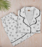 White satin pajama set: button shirt and shorts with smiley print, lace-edged trim