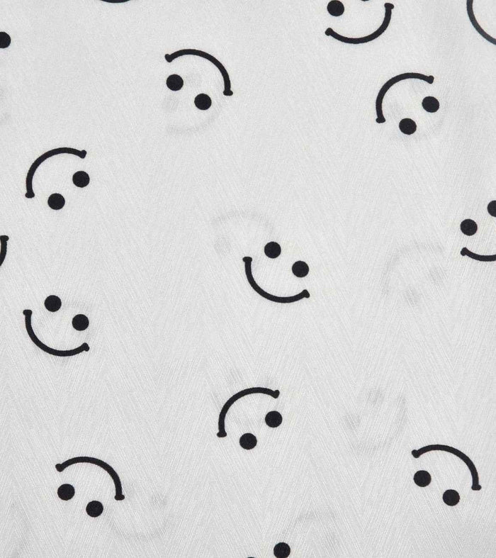 White satin fabric with black smiley face print