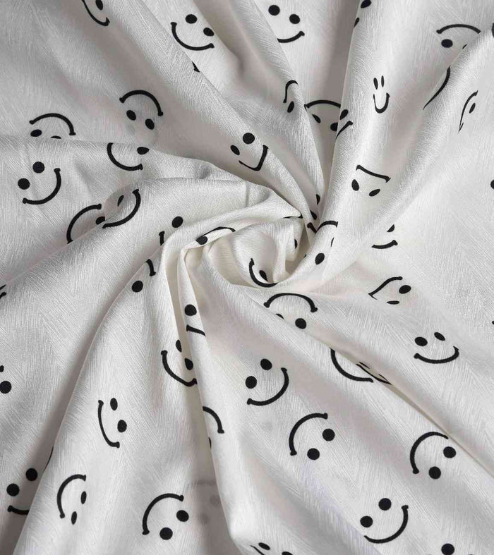 White satin nightwear fabric with black smiley faces, soft drape
