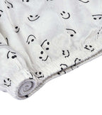 White pajama shorts hem with elastic edge and black lace trim, smiley print