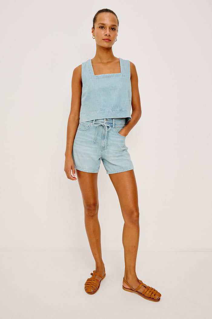 Rancho Short in Cotton Lyocell Denim With High-Rise, Pinched Waist, A-Line Silhouette, Relaxed Saddle, Front Drawcord Ties, and Zip Fly in Surf Colorway - Full Body Front View Featured on Model