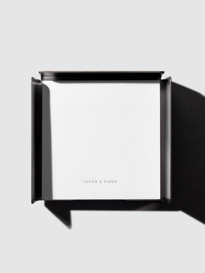 Sticky note holder displayed on a neutral background with sticky note placed inside.