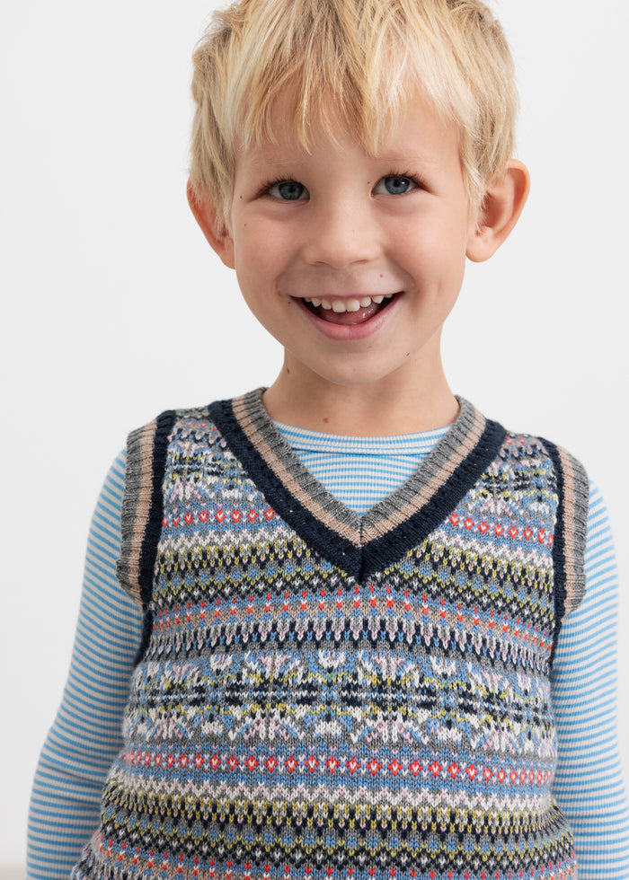 Boy wearing patterned knitted vest over light blue blouse