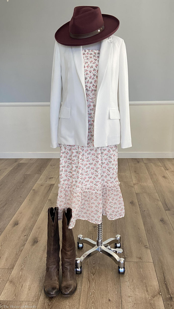 White tailored-welt-pocket-open-blazer over floral Talluleh midi dress with dark brown wide-brim hat and vintage brown leather boots on wooden floor