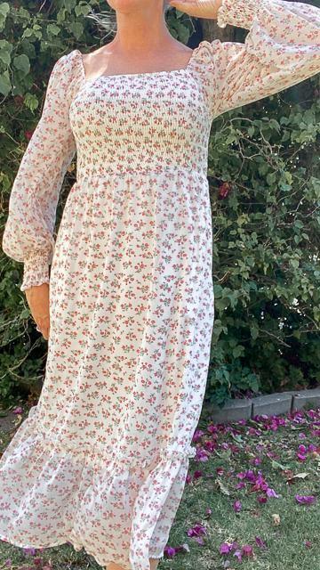 Woman wearing a long-sleeve, square neck, ditsy floral midi dress standing outdoors in garden