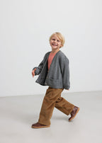 Boy in brown corduroy pants with gray knitted cardigan