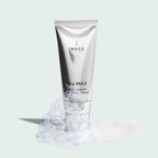 the MAX™ facial cleanser | IMAGE Skincare in a sleek silver tube surrounded by cleansing foam and bubbles on a light background, highlighting skincare and cleansing essentials
