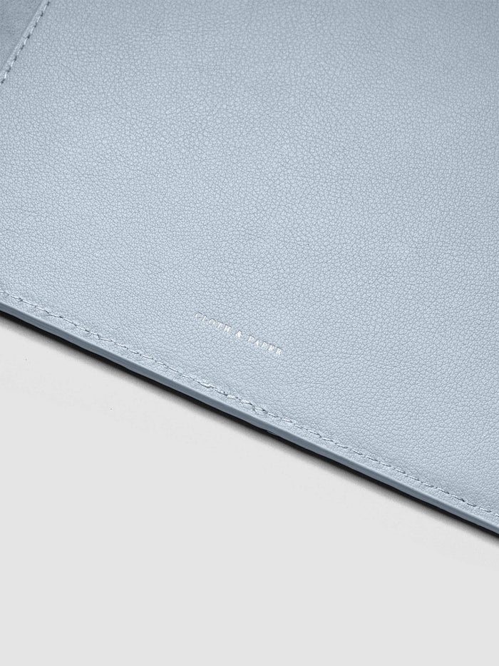 Close up of the foil Cloth & paper logo on the interior of a blue leather planner folio cover.